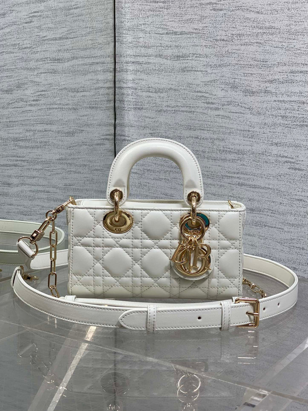 Dior quilted handbag in white with top handles, gold hardware, and a crossbody strap