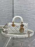 Dior quilted handbag in white with top handles, gold hardware, and a crossbody strap