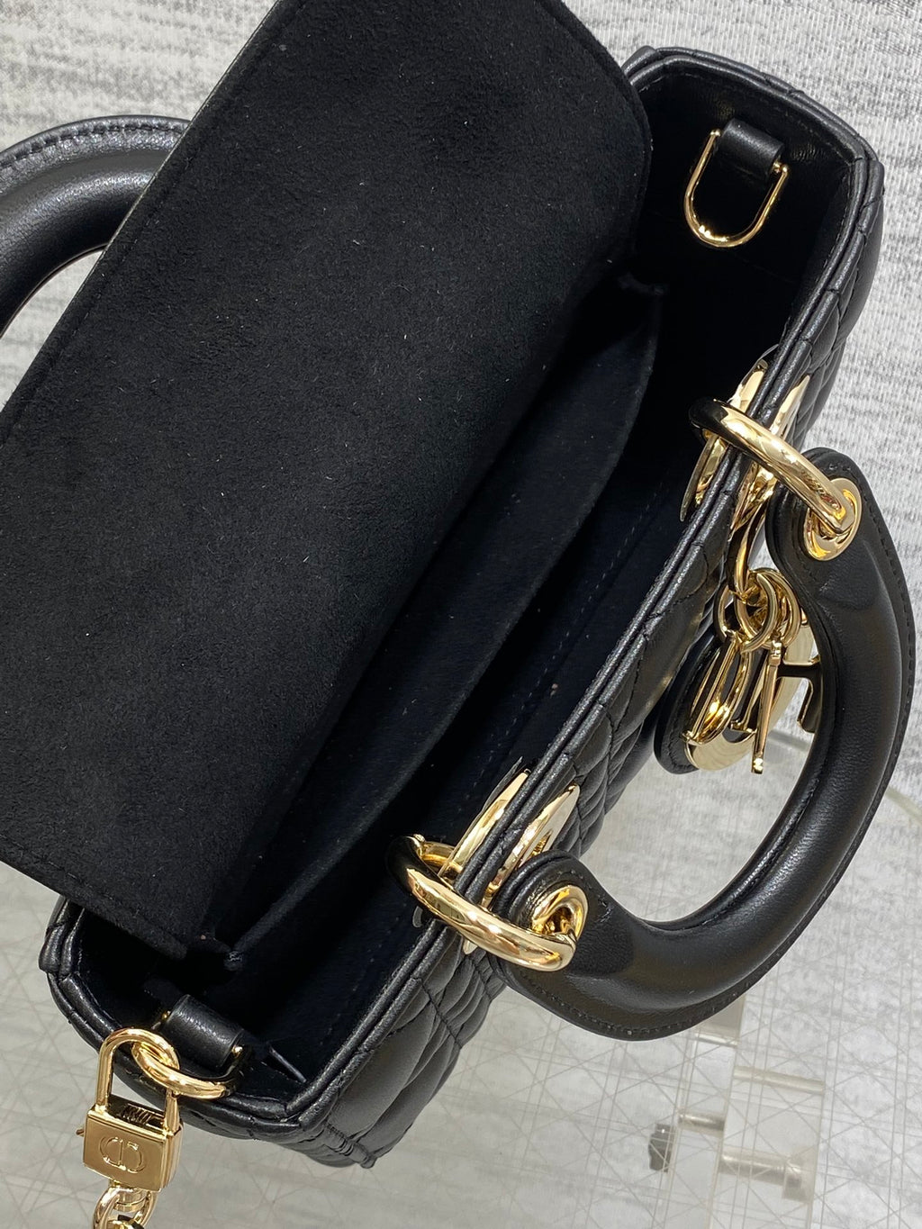 Dior quilted handbag with black strap and gold-tone buckle and charm hardware