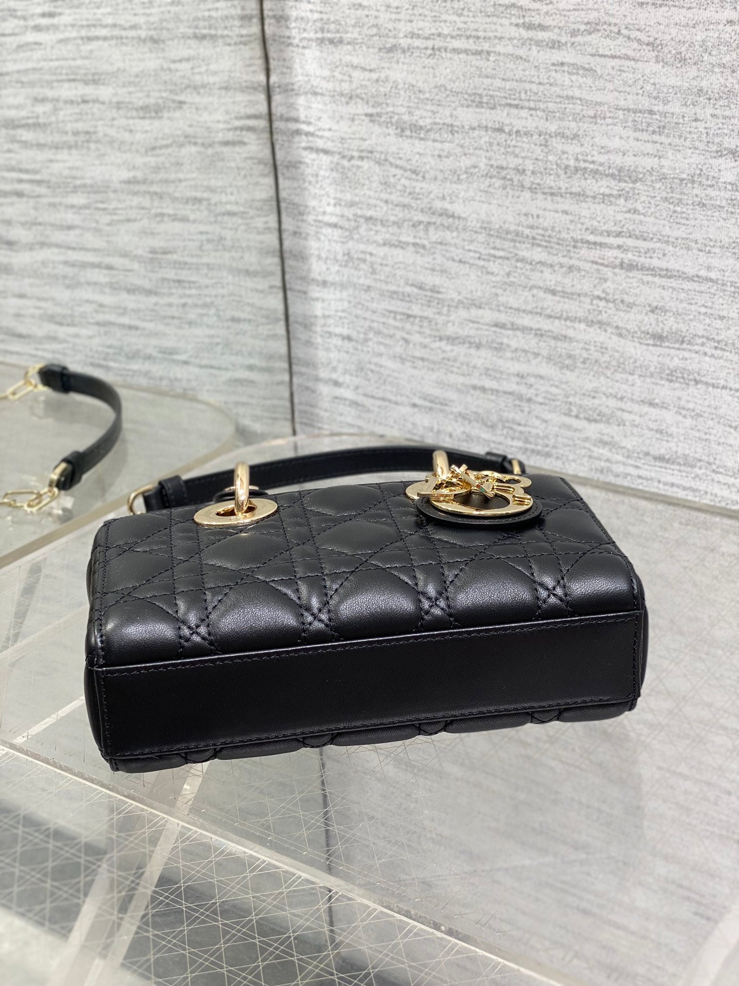 Dior quilted mini handbag top view with gold Dior emblem and short top handle