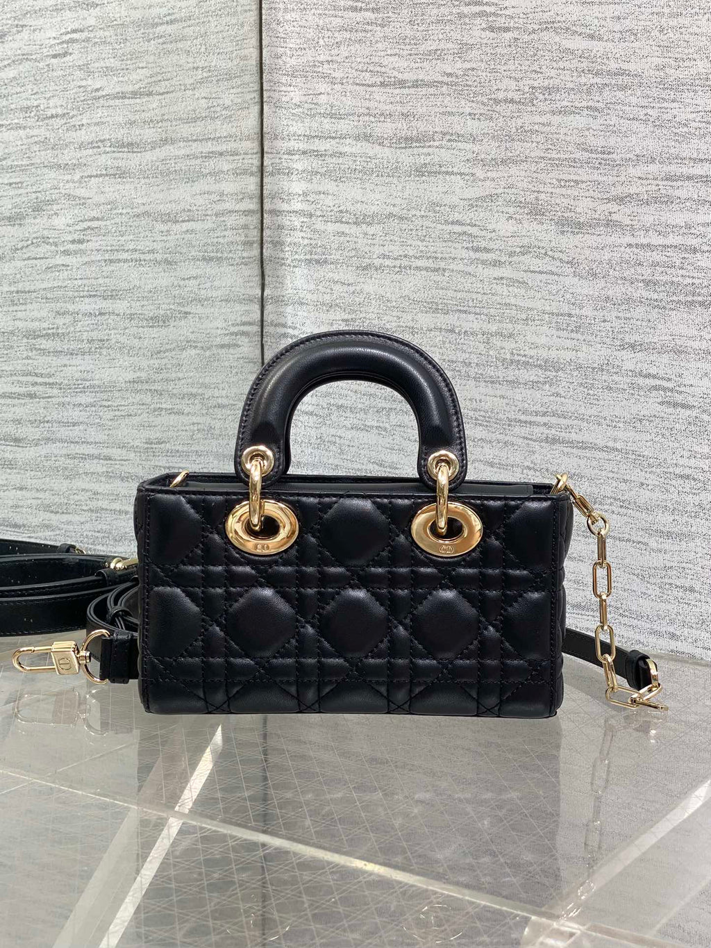 Dior quilted mini handbag front view with top handles, gold rings, and crossbody strap