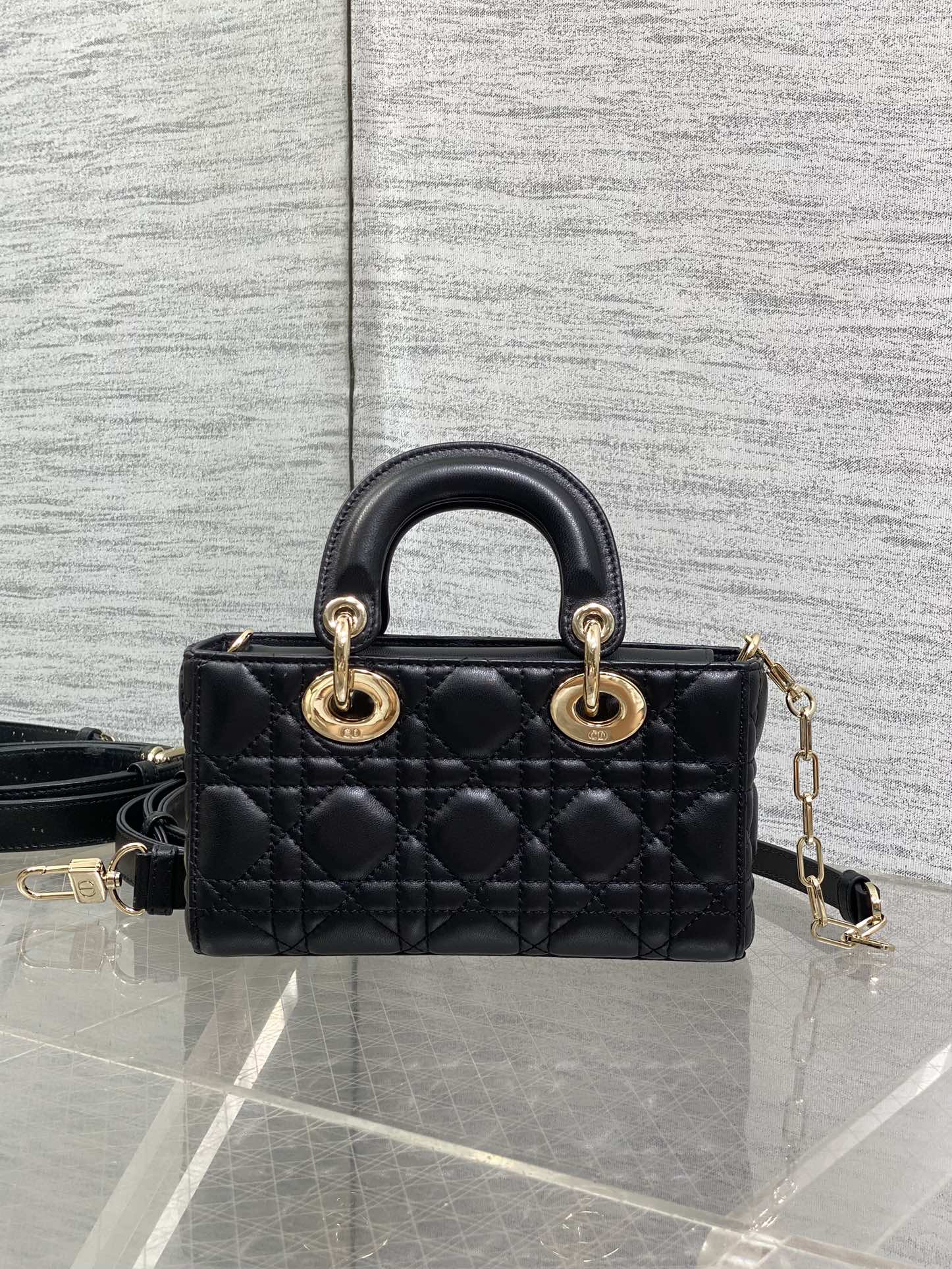 Dior quilted mini handbag front view with top handles, gold rings, and crossbody strap