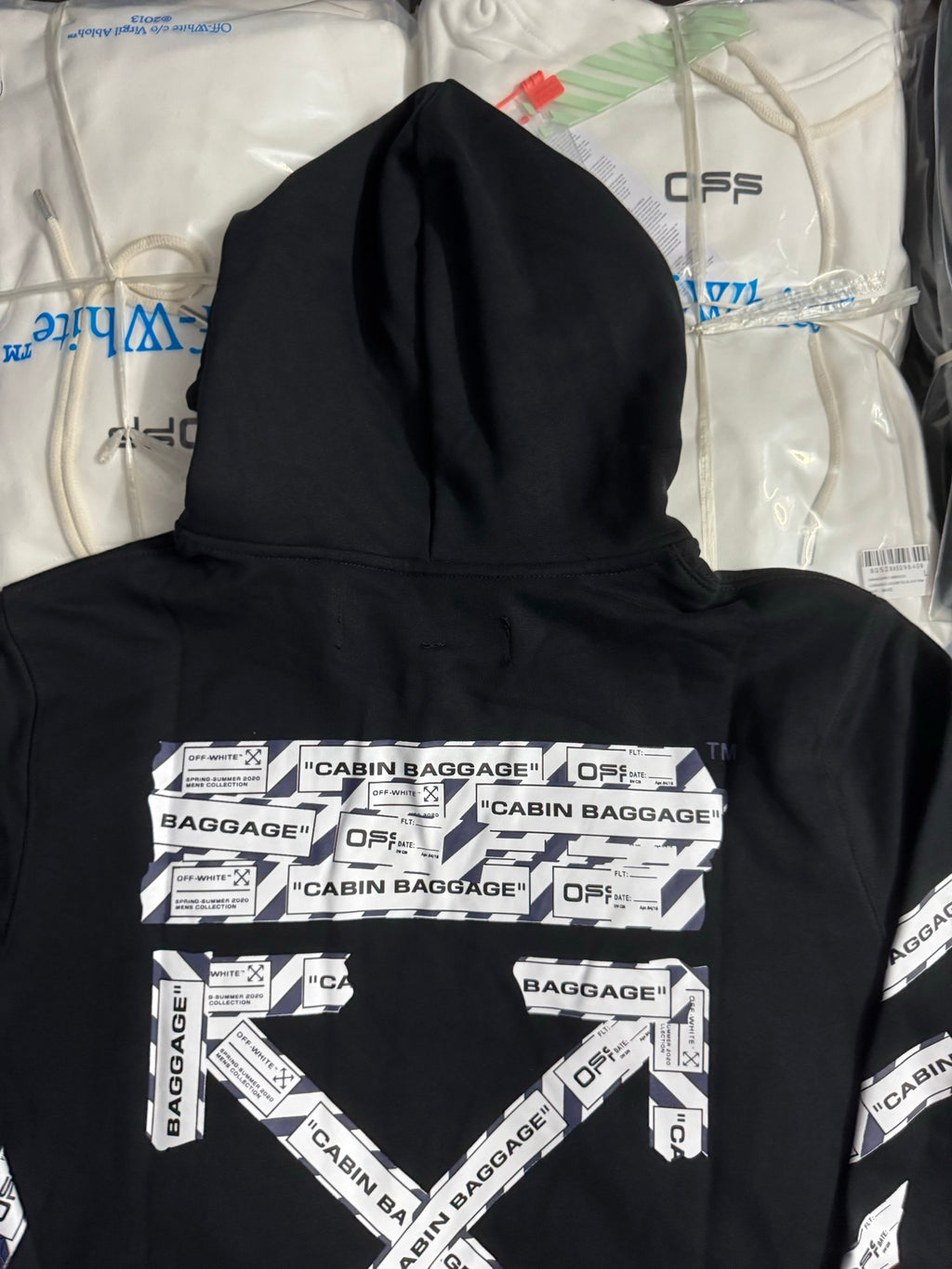 Black hoodie back close-up with CABIN BAGGAGE panel graphic and OFFS marks