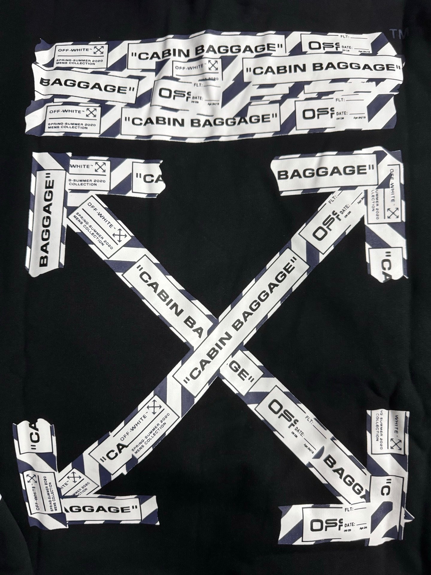 Black hoodie with large V-shaped CABIN BAGGAGE text print and scattered labels.