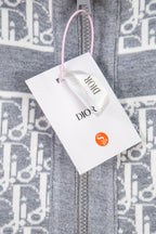 Grey knit zip jacket close-up with monogram trim and Dior brand tag