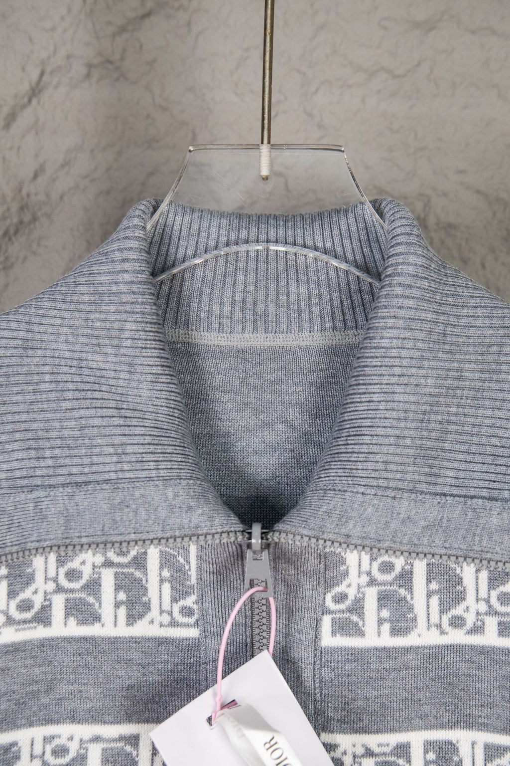 Grey knit sweater top with ribbed collar and cuffs, monogram band along zipper