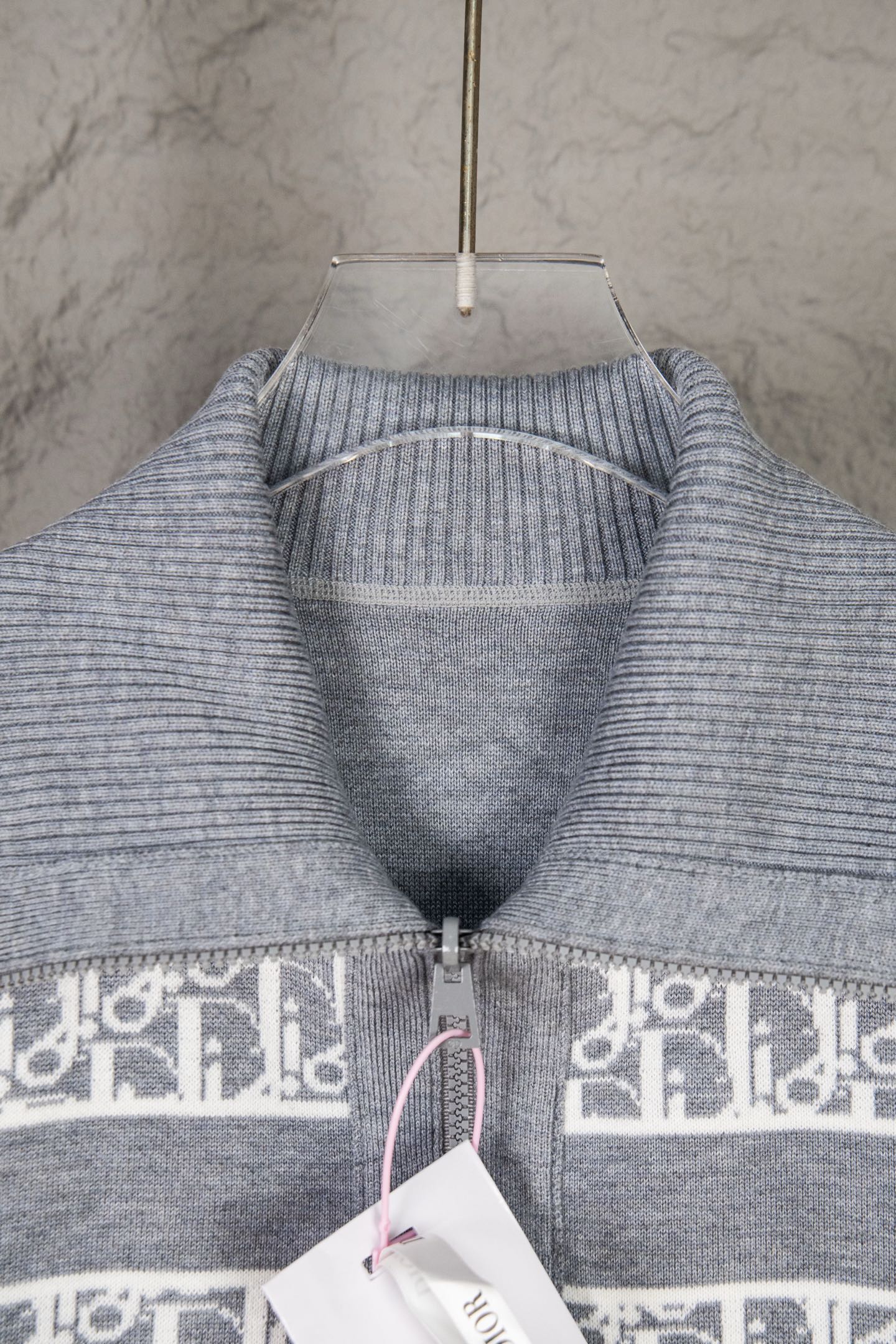 Grey knit sweater top with ribbed collar and cuffs, monogram band along zipper