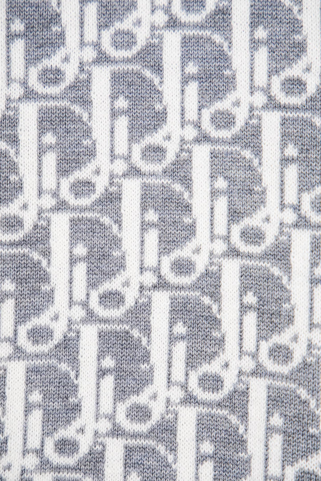 Grey knit fabric with white allover monogram pattern close-up
