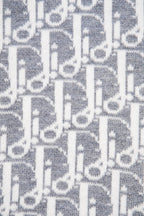 Grey knit fabric with white allover monogram pattern close-up