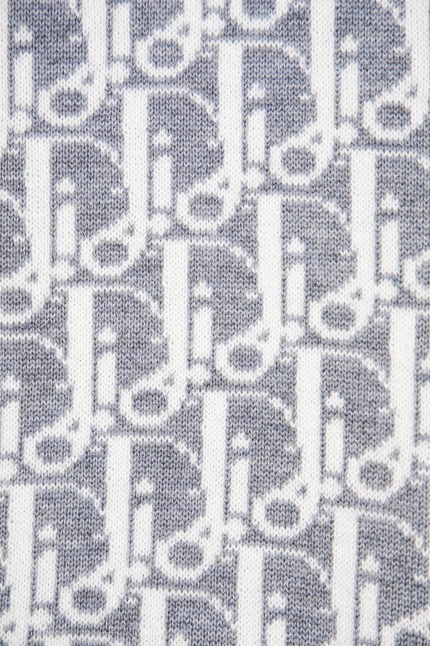 Grey knit fabric with white allover monogram pattern close-up