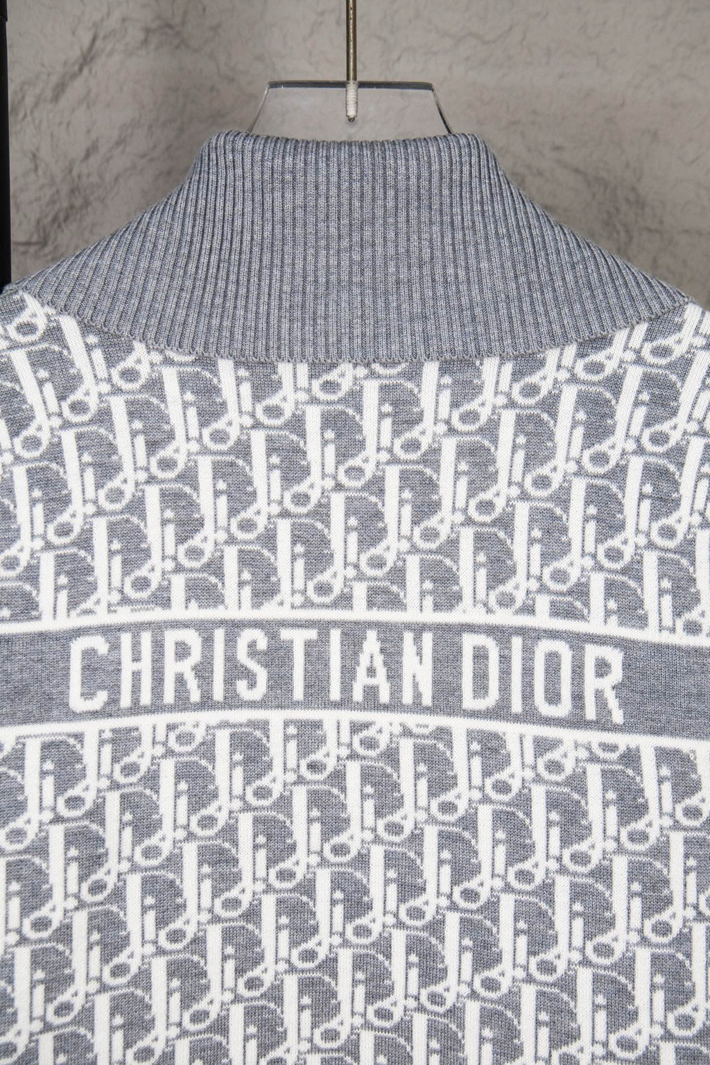 Grey knit sweater with Christian Dior logo across chest and allover monogram pattern