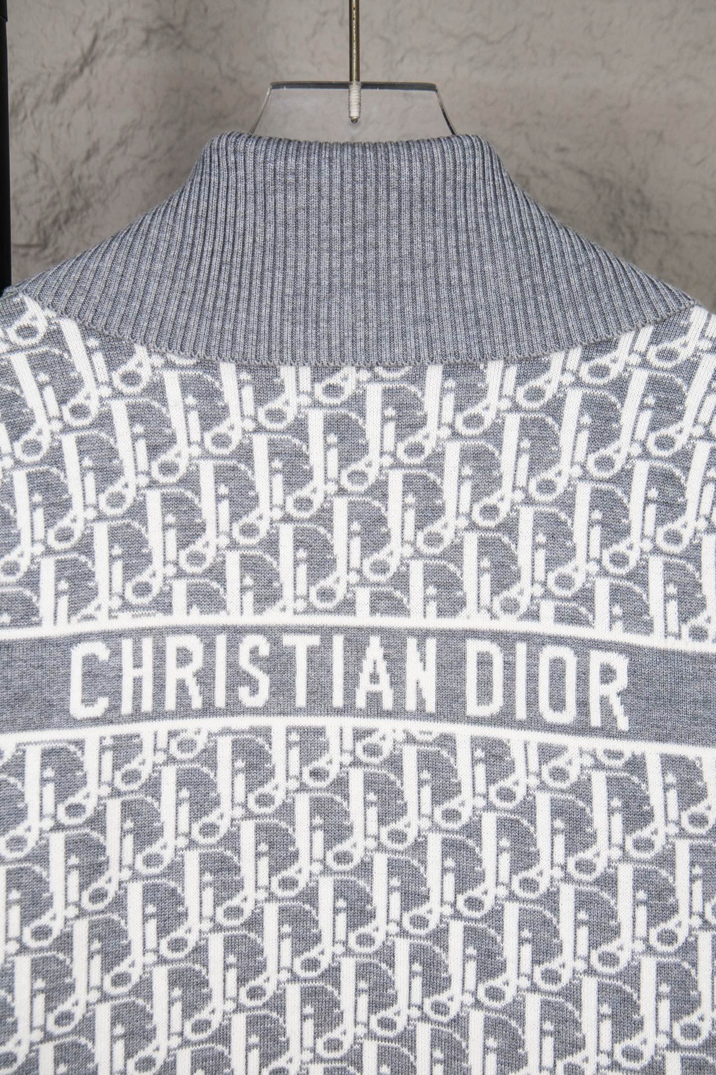 Grey knit sweater with Christian Dior logo across chest and allover monogram pattern