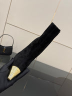 YSL women’s black suede boot held upright, pointed gold-tone toe cap visible