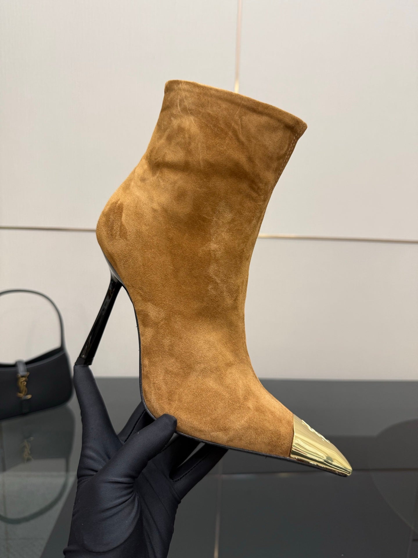 Tan suede ankle boot with pointed gold-tone toe and back zip detail