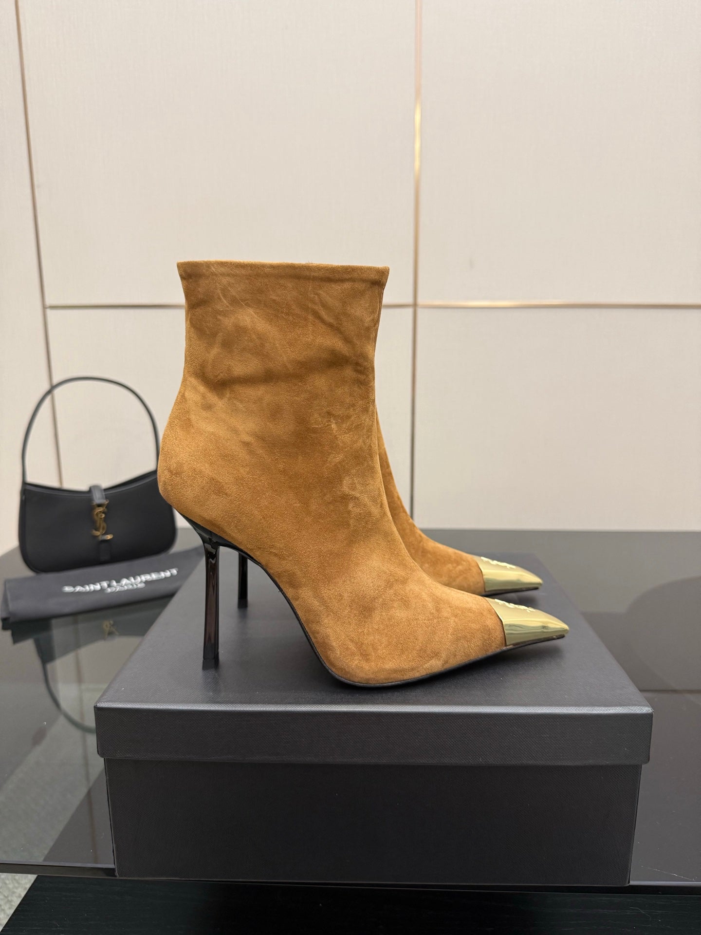Tan suede ankle boot with pointed gold-tone toe and slender black stiletto heel