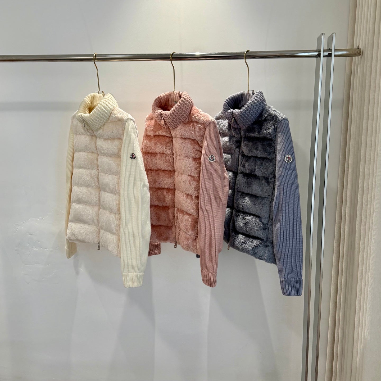 Set of long puffer jackets: cream, blush pink, and dark blue with knit collars.