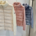 Close view of long puffer jackets: cream, blush pink, and dark blue with turtlenecks.