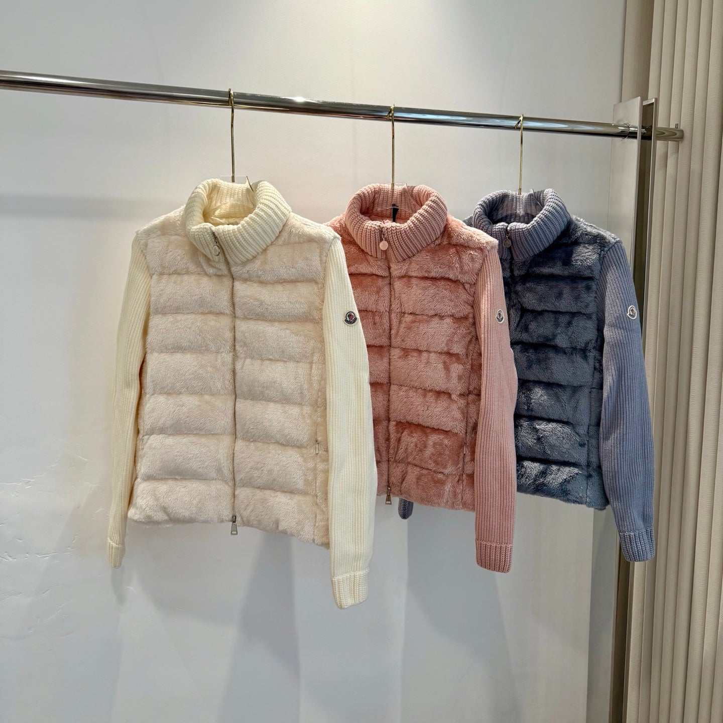 Cream long puffer jacket with knit turtleneck, buttoned front, quilted panels.