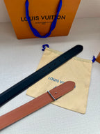 Navy and tan leather belts with metal buckles, laid flat