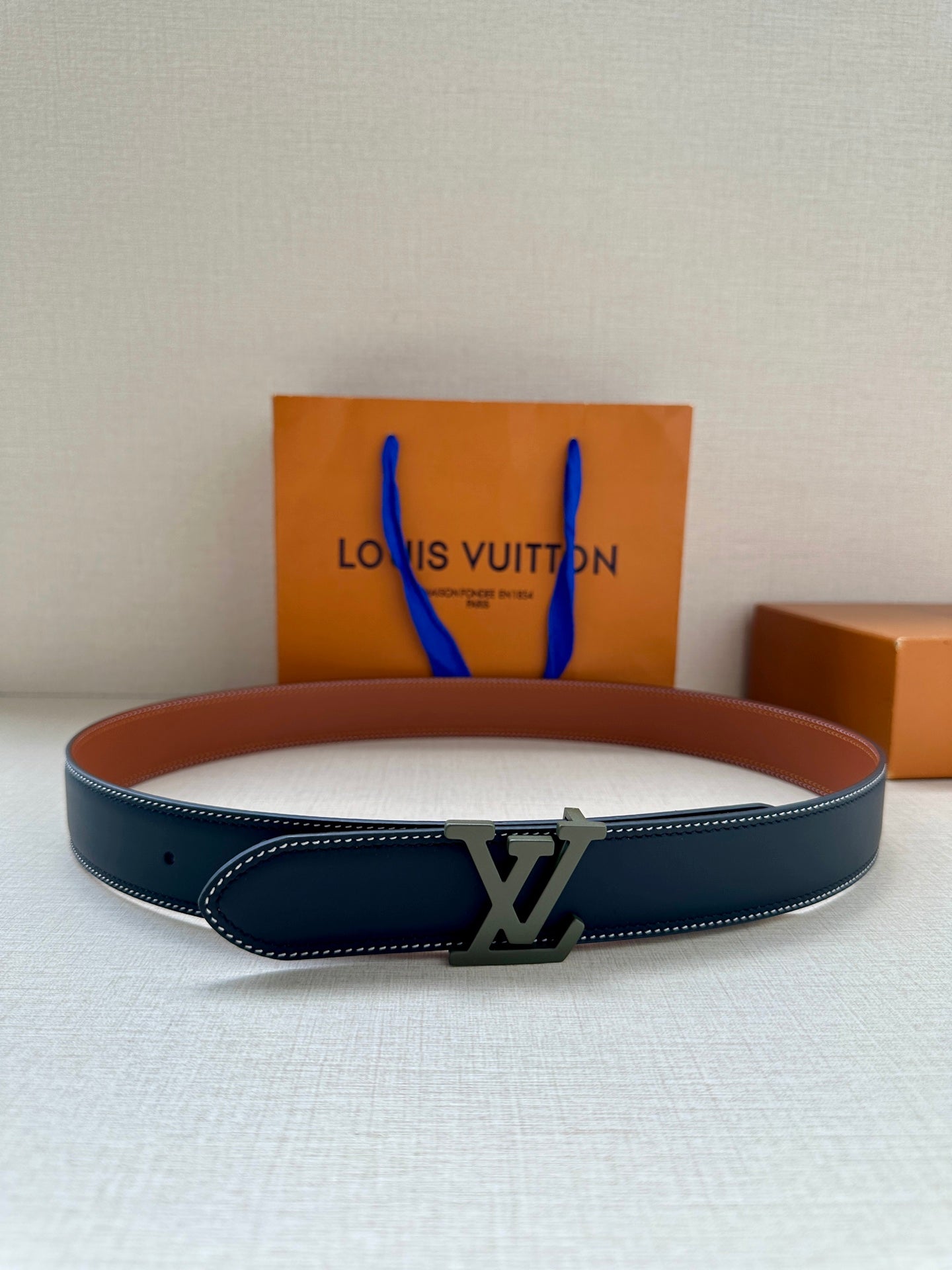 Louis Vuitton leather belt with dark blue strap and silver-toned LV buckle