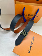 Louis Vuitton belt laid out: dark blue leather strap with LV buckle and orange lining