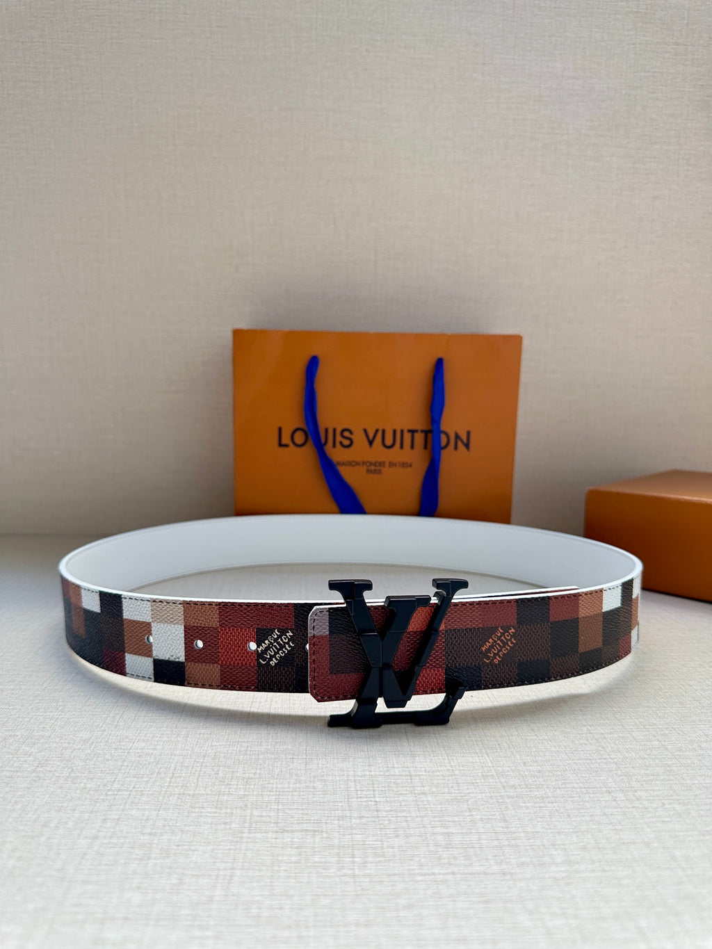 Louis Vuitton belt with multicolor check strap and dark LV buckle, wide width.