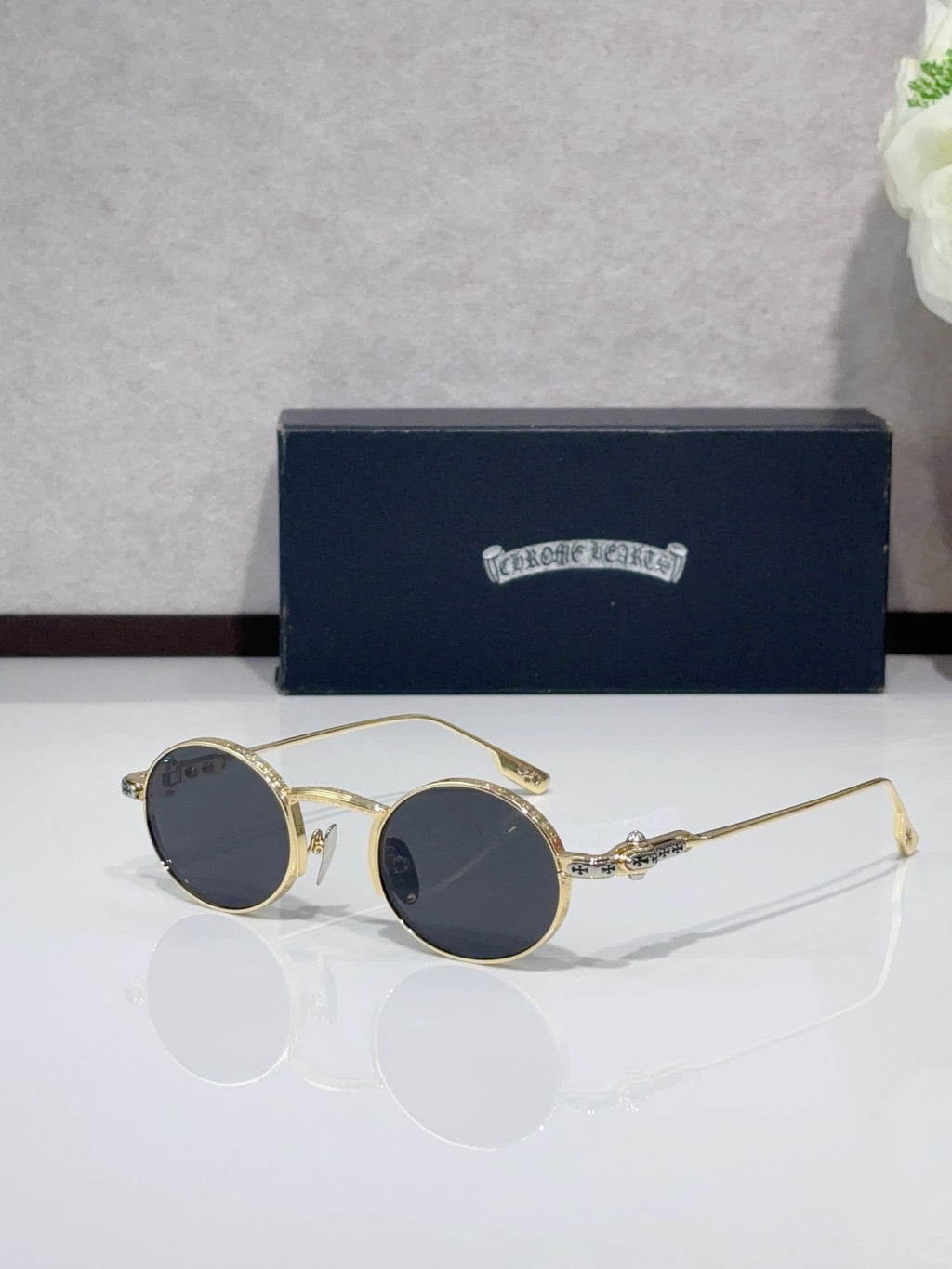 Round metal glasses with gold frames and dark blue tinted lenses