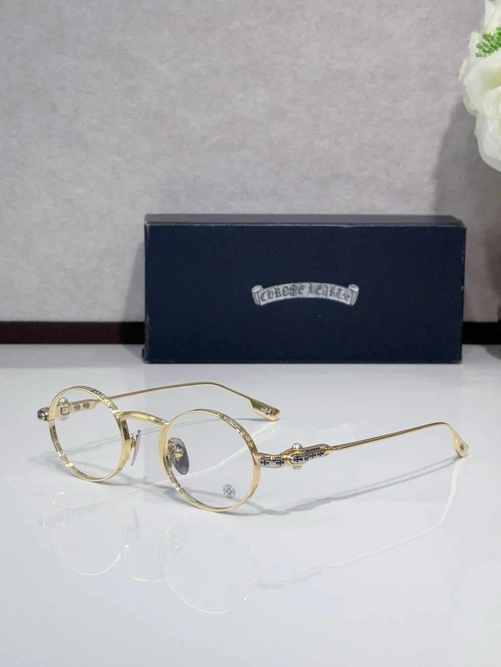 Round metal glasses with gold frames and clear tinted lenses