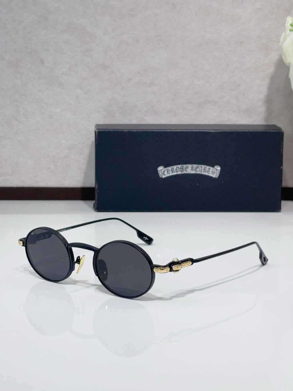 Round metal glasses with black frames and dark gray tinted lenses