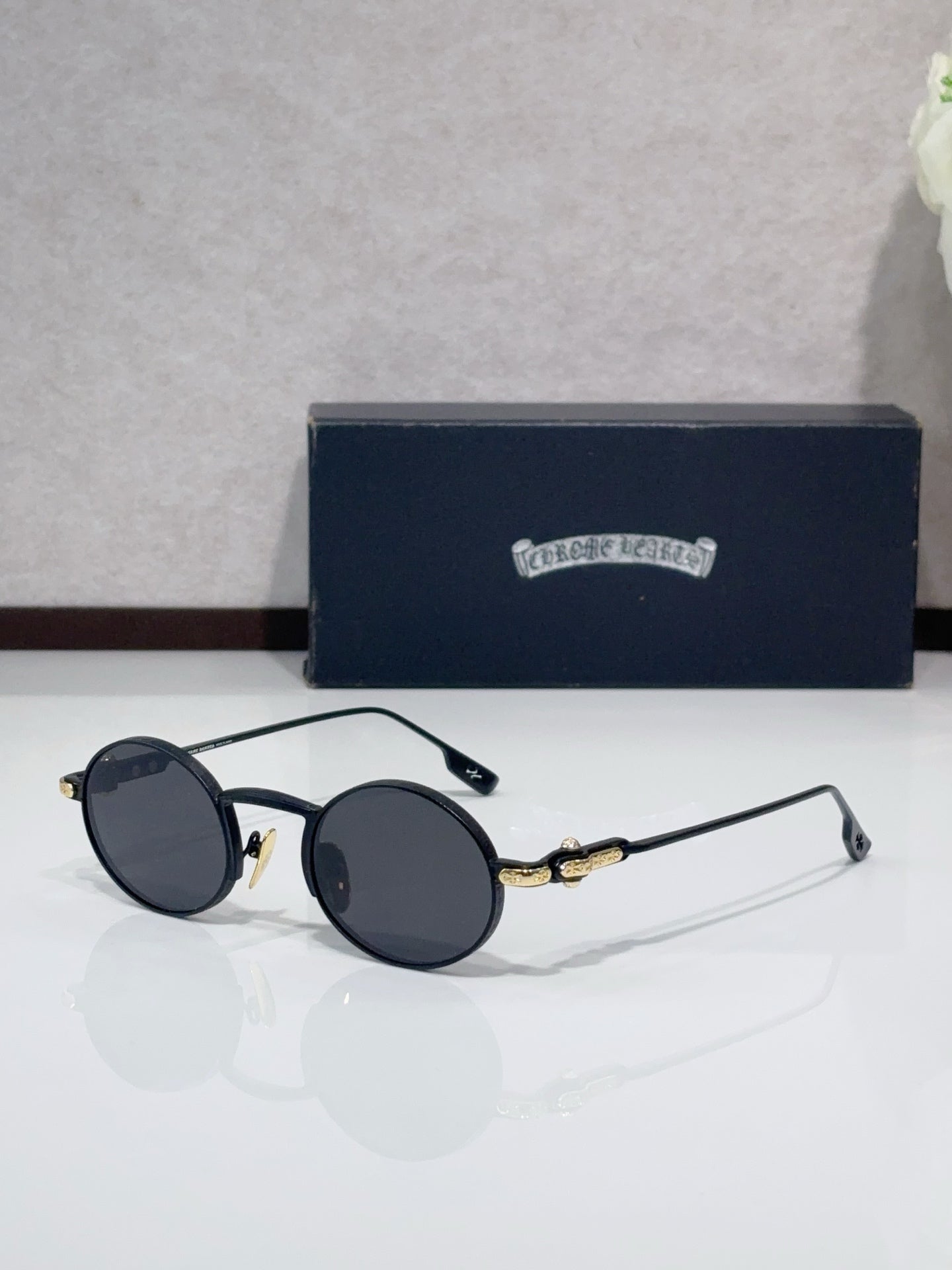 Round metal glasses with black frames and dark gray tinted lenses