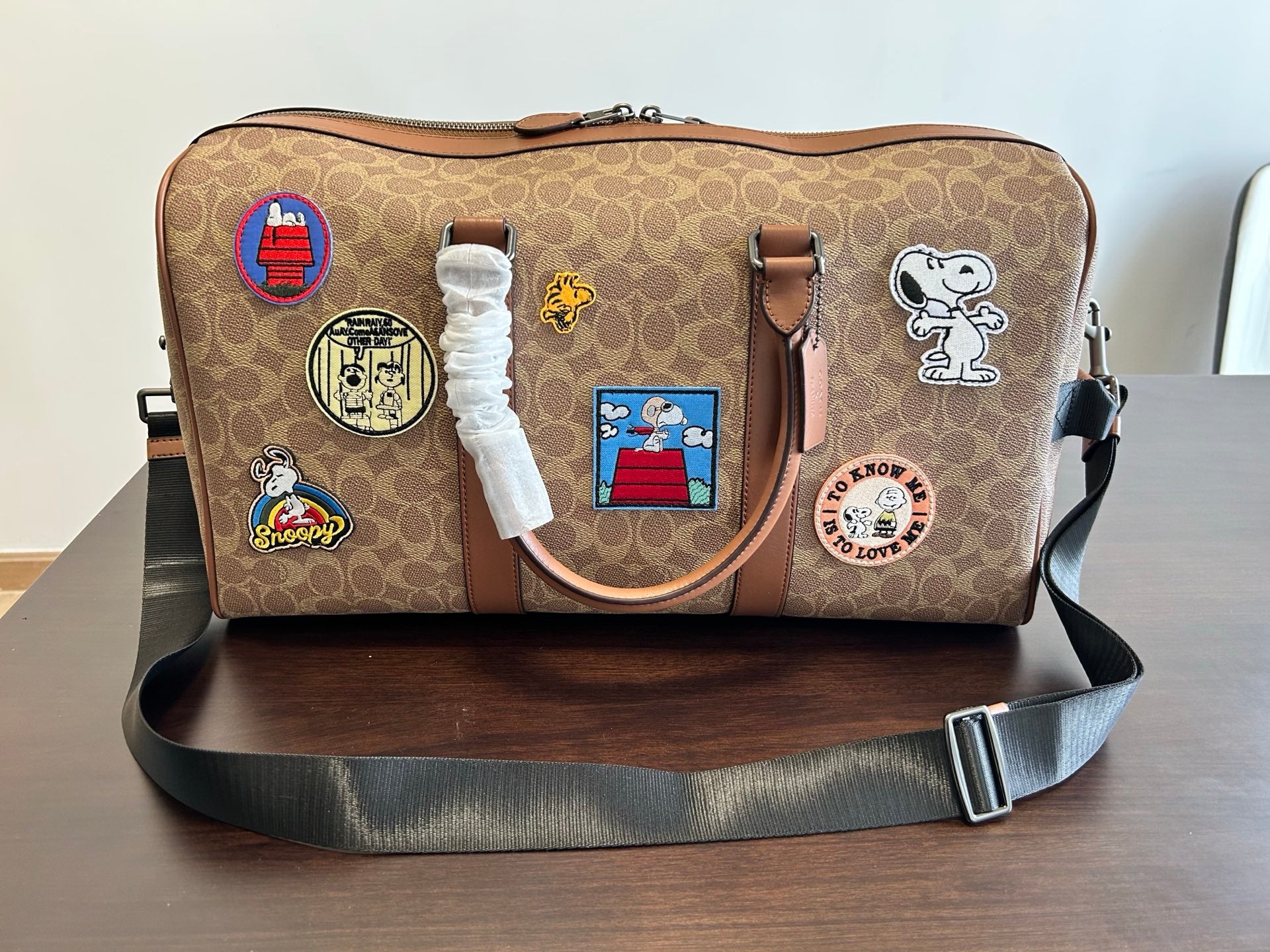 Coah duffel bag with adjustable shoulder strap, monogram canvas, patch front and side