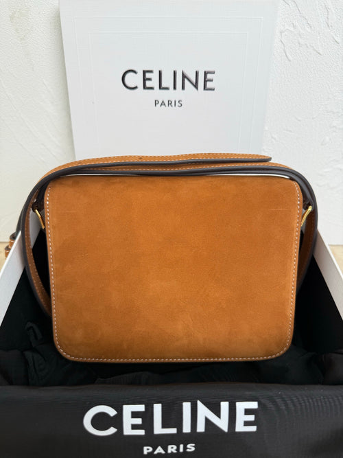 Tan suede Celine bag with flap closure and dark trim; side view with top handle.