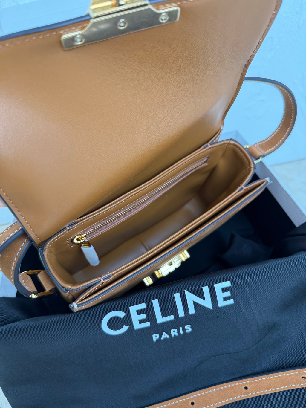 Celine bag opened to show interior pocket; gold-tone zipper and logo hardware at front.