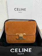 Celine bag in tan suede with front flap and metal emblem clasp; top handle and strap.