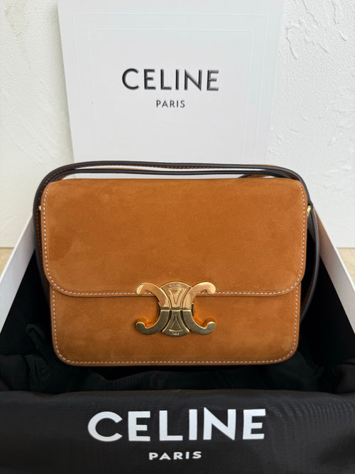 Celine bag in tan suede with front flap and metal emblem clasp; top handle and strap.