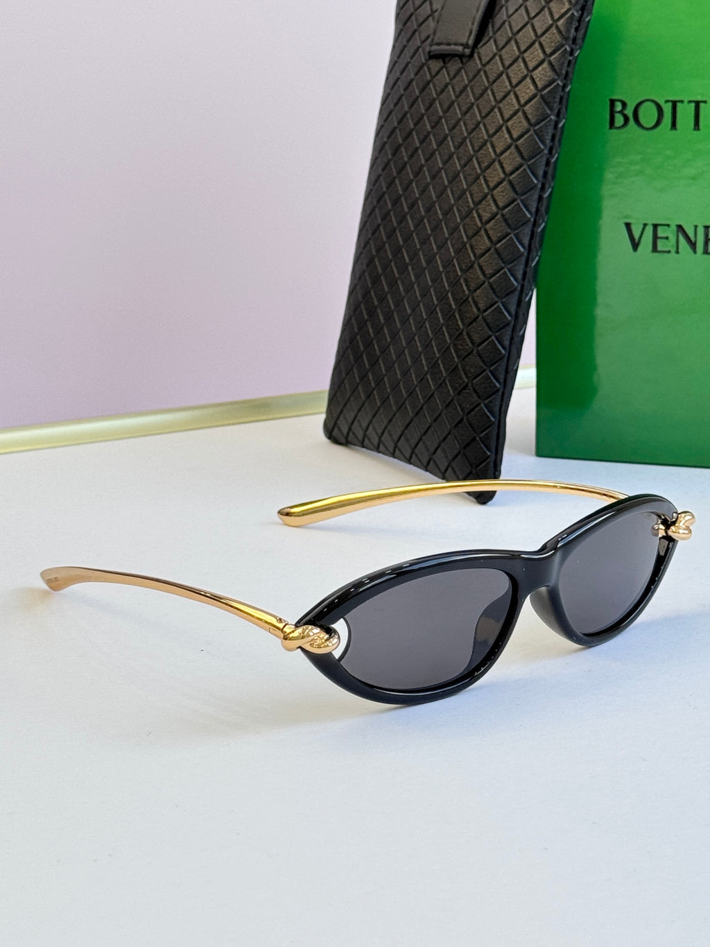 Bottega Veneta black cat-eye glasses side view with dark lenses and gold-tone arms