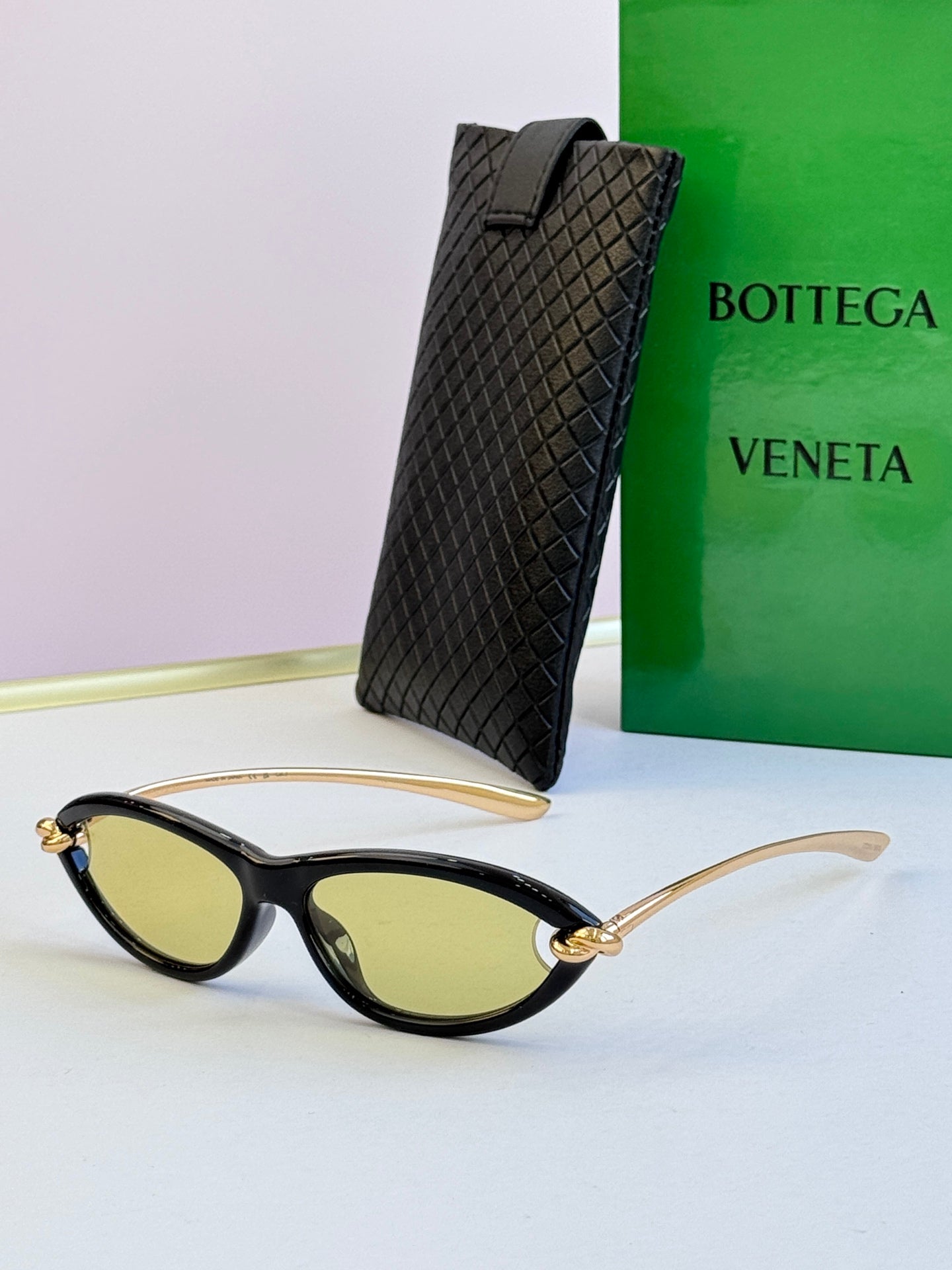 Bottega Veneta black cat-eye glasses with yellow-tinted lenses and gold-tone temples