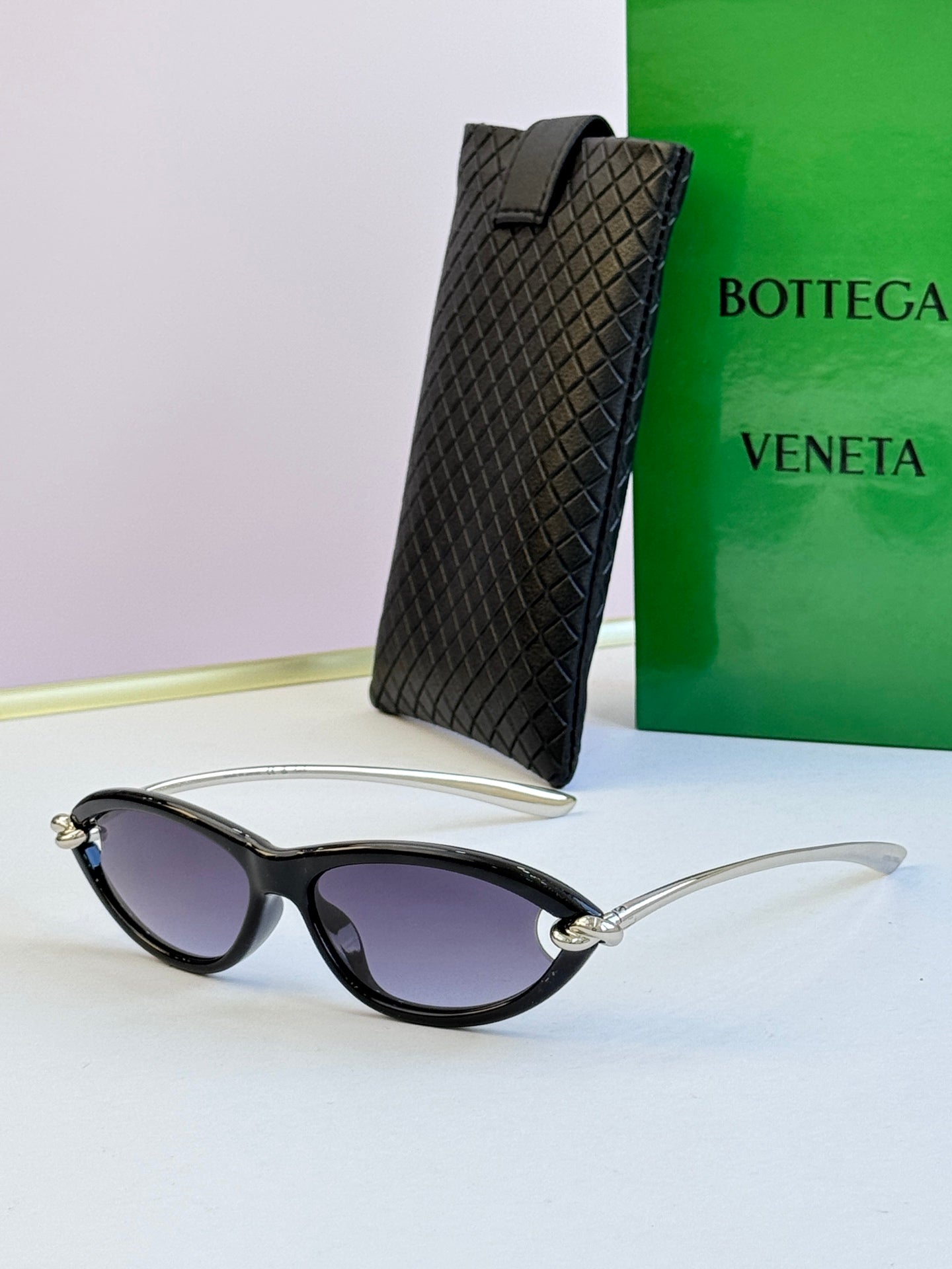Bottega Veneta black cat-eye glasses with light purple-tinted lenses and gold-tone rims