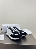 Black and white low-top sneakers with chunky tread sole and contrast panels