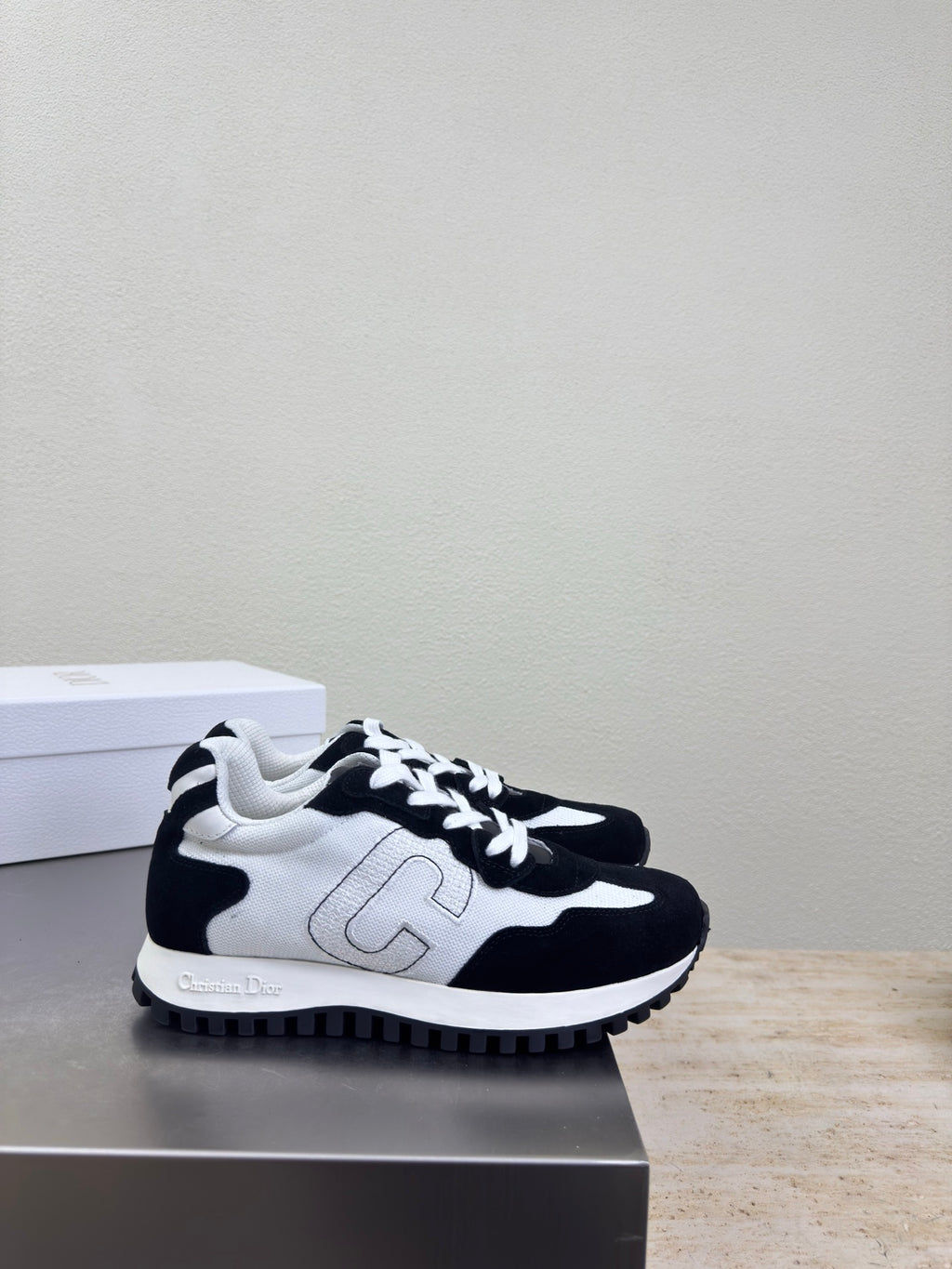 Black and white low-top sneakers with white side emblem and lace-up design