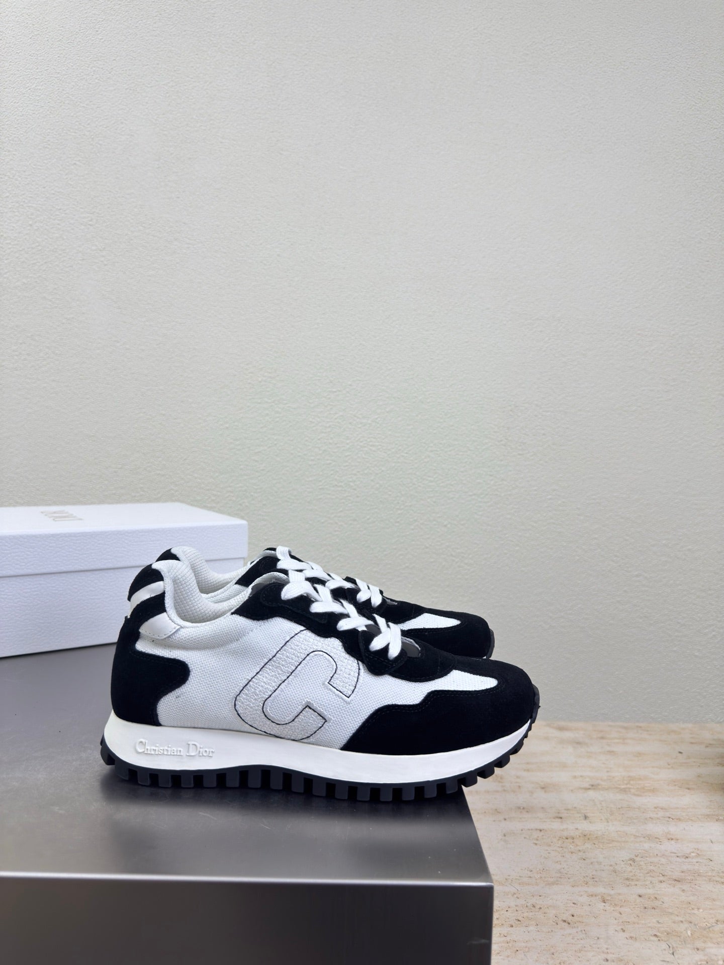 Black and white low-top sneakers with white side emblem and lace-up design