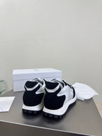 Pair of black and white low-top sneakers with chunky tread sole and lace-up front