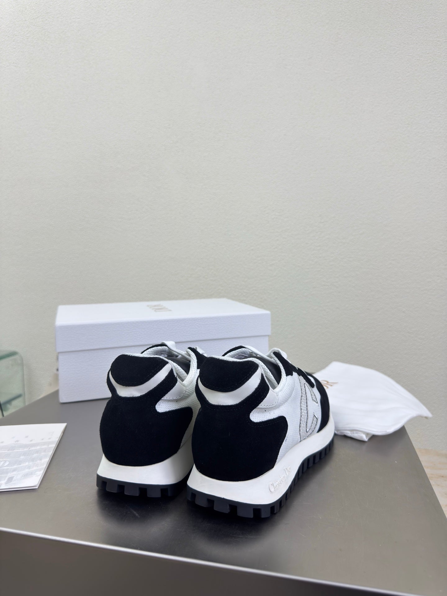 Pair of black and white low-top sneakers with chunky tread sole and lace-up front