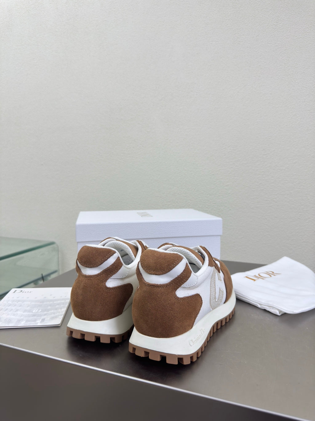 Brown and white sneakers on display with white laces, heel and side view