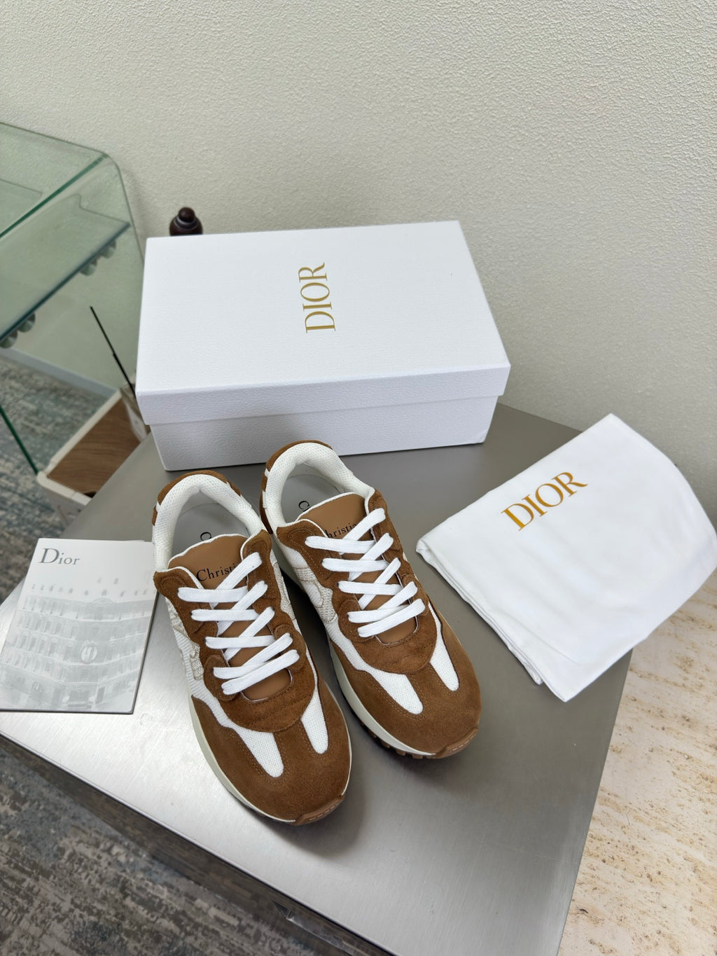 Brown and white high-top sneakers with white laces and chunky sole, with cloth bag