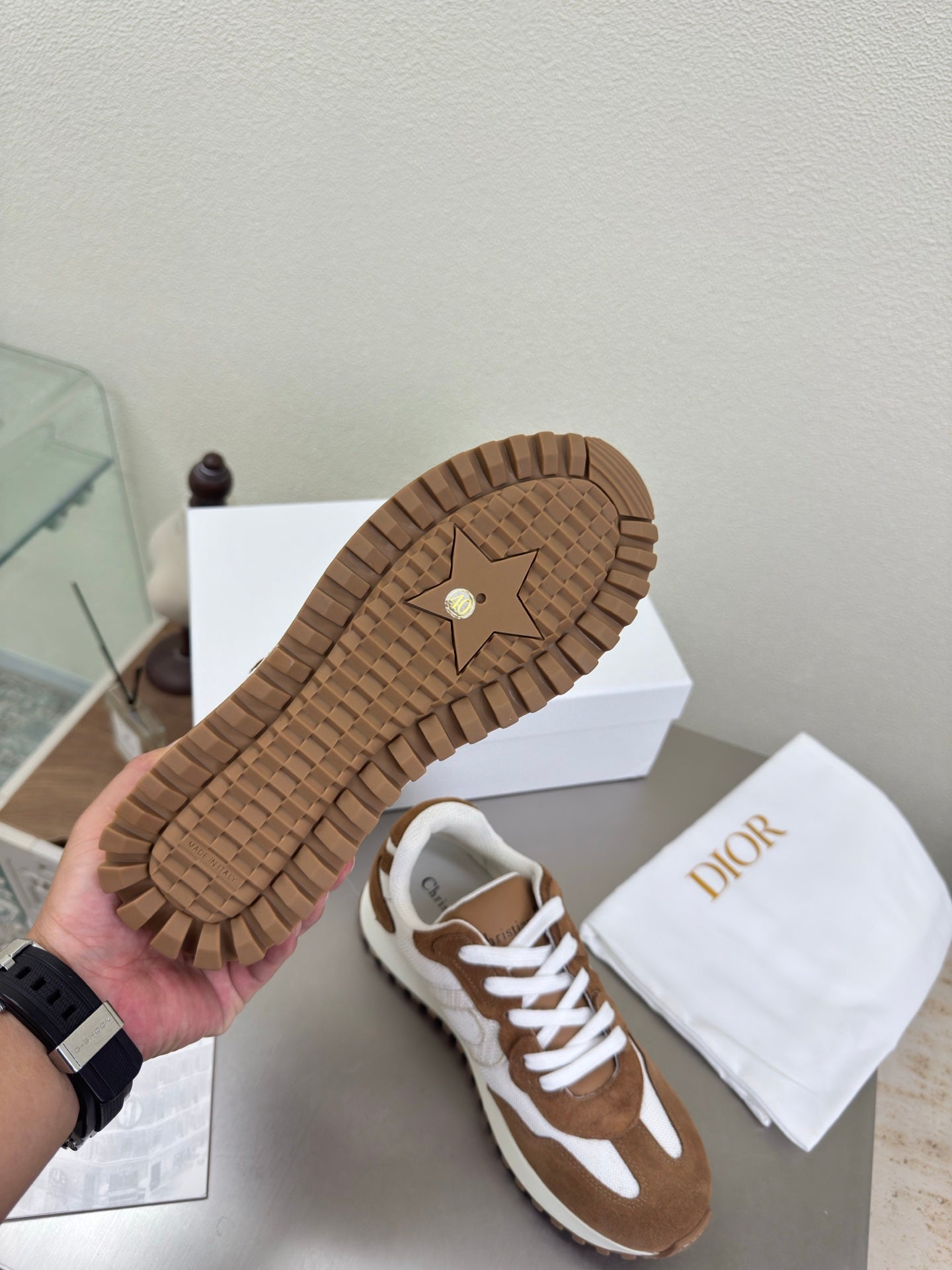 Brown and white sneakers showing treaded outsole and side panels, pair on box