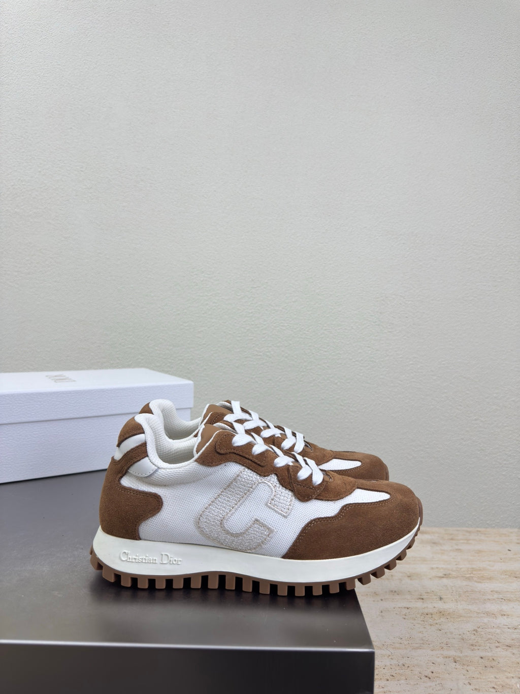 Brown and white sneakers with white laces and logo detail, side angle