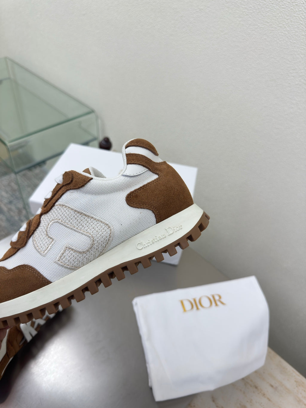 Brown and white sneaker with suede and leather panels, close-up of side and sole tread
