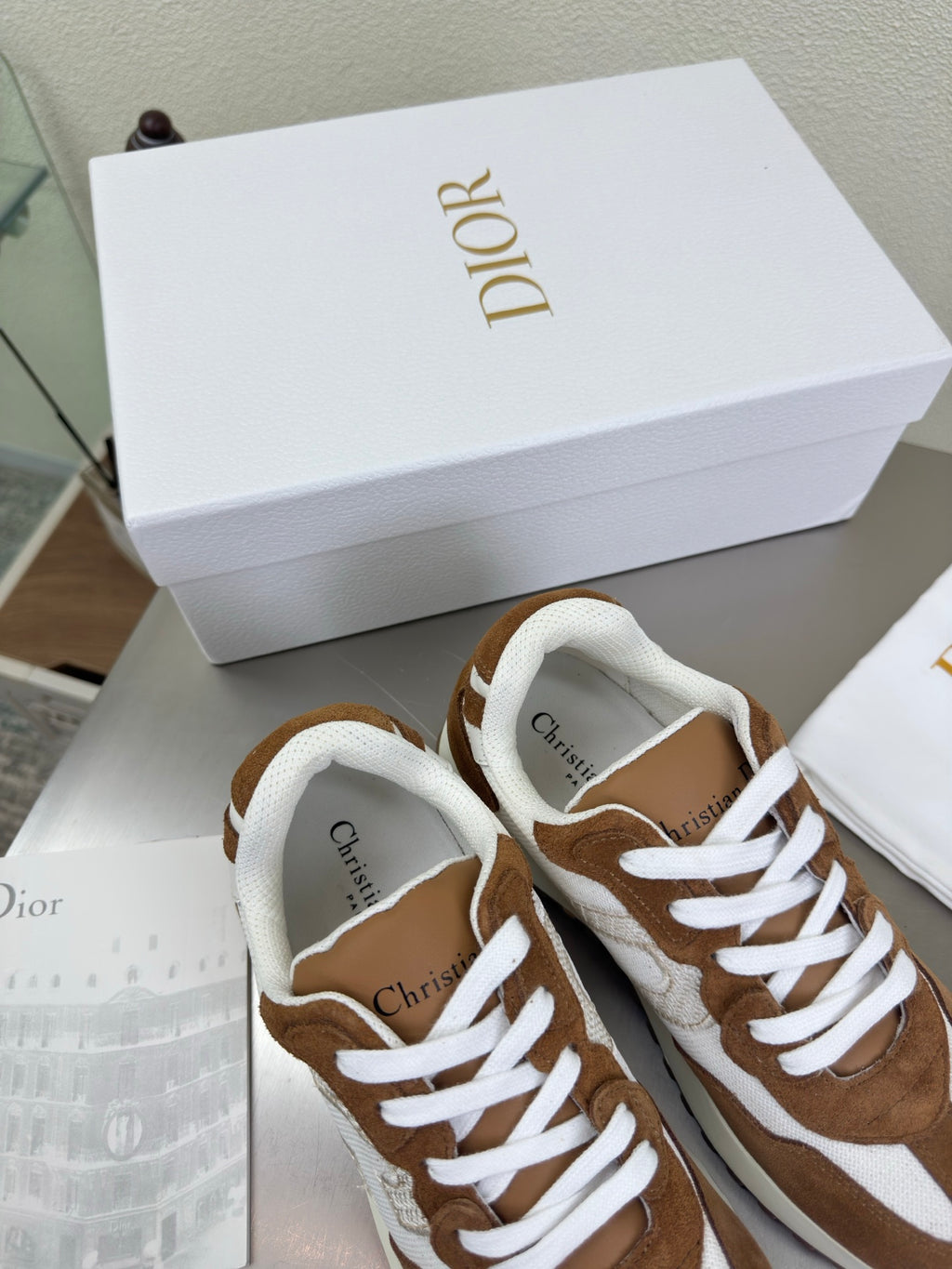 Brown and white low-top sneakers with white laces and padded collar, side view close-up