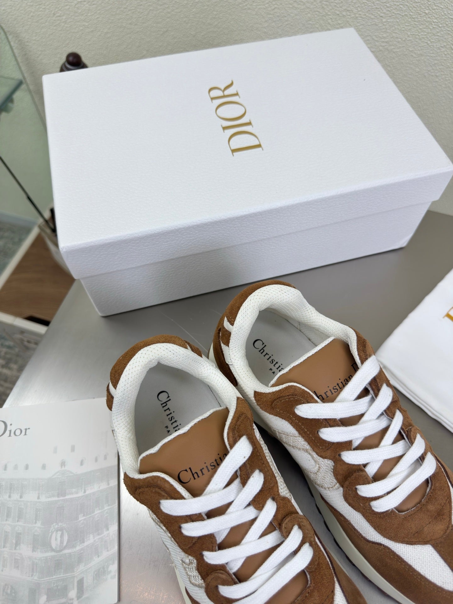 Brown and white low-top sneakers with white laces and padded collar, side view close-up
